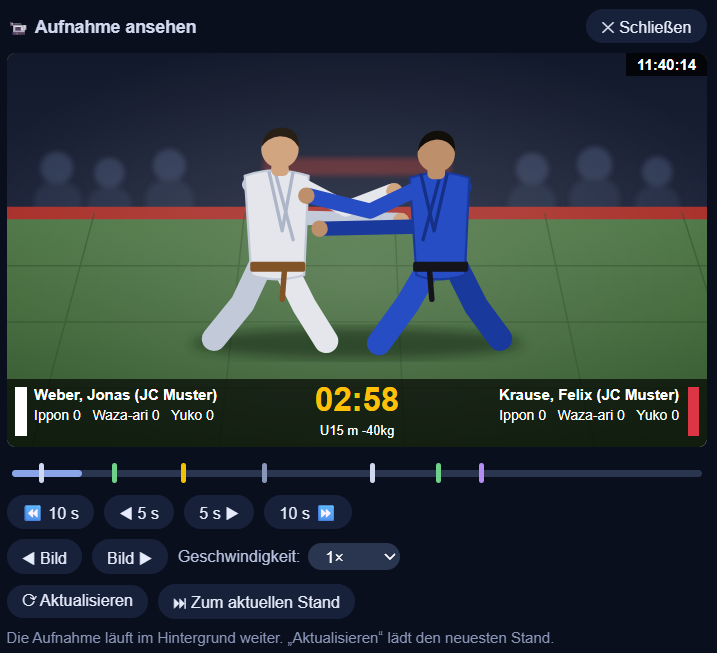 Die Videoansicht in der Steuerung: zwei Kämpfer auf der Matte mit eingeblendeter Kampfzeit und Namen, darunter die Zeitleiste mit farbigen Marken für Start, Wertungen, Strafen, Haltegriff und Stopp